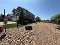 Landscaped backyard with gravel and large rocks surrounding the home at 653 Glenarbor Cir, Longmont, CO 80504