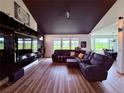 An entertainment center spans an entire wall in this living room with a wall-mounted fireplace and lots of natural light at 653 Glenarbor Cir, Longmont, CO 80504
