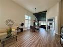 Spacious living room featuring a vaulted ceiling, dining area, and wood-look floors with an open floorplan at 653 Glenarbor Cir, Longmont, CO 80504