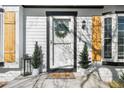 Close-up of a welcoming front door framed by elegant wood shutters and lush potted plants at 4733 S Vivian Ct, Morrison, CO 80465