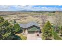 Expansive aerial view showcasing the home's setting with mountain views, mature trees, and large lot at 7701 Hillgate Way, Parker, CO 80134