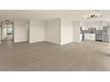 Open living space leading to the kitchen featuring hardwood floors and neutral walls at 800 N Washington St # 1010, Denver, CO 80203