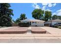 Inviting single-story home featuring brick accents and a spacious driveway on a sunny day at 420 E 104Th Pl, Northglenn, CO 80233