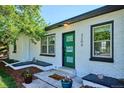 Welcoming front entrance with a green door, white brick, and attractive landscaping at 3200 Ames St, Wheat Ridge, CO 80212