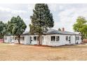Sprawling white brick home featuring multiple windows, lush landscaping, and meticulous yard maintenance at 4023 E Martin Luther King Jr, Denver, CO 80207