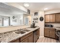 Functional kitchen featuring granite countertops, stainless steel appliances, and a view into the living space at 14602 E 2Nd Ave # 110C, Aurora, CO 80011