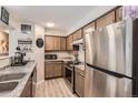 Well-equipped kitchen with stainless steel refrigerator, granite countertops, and updated appliances at 14602 E 2Nd Ave # 110C, Aurora, CO 80011
