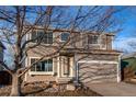 Two-story house with attached garage and mature tree in front at 1225 Briarhollow Way, Highlands Ranch, CO 80129