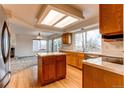 Kitchen with island, wood cabinets, and stainless steel appliances at 1225 Briarhollow Way, Highlands Ranch, CO 80129