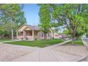 Residential street view of a charming brick house with a covered front porch and trees at 218 E Colorado Ave, Berthoud, CO 80513