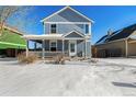Two-story house with gray siding, covered porch, and snow-covered yard at 2728 Renshaw St, Strasburg, CO 80136