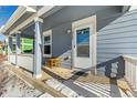 Covered porch with wooden railings and a small table and chairs at 2728 Renshaw St, Strasburg, CO 80136