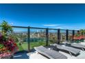 Relax on the rooftop deck with city views, featuring lounge chairs and planters with colorful flowers at 1133 Race St # 8 & 9 B, Denver, CO 80206