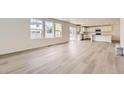 Open-concept living area with modern flooring flowing into the kitchen with stainless steel appliances at 22014 E 39Th Ave, Aurora, CO 80019