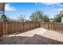 View of the fenced backyard with stone paving and a pathway, offering a private outdoor space at 7845 Barbara Ann Dr # J, Arvada, CO 80004