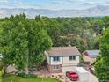 Aerial view of the home showcasing its well-maintained lawn, mature trees, and convenient driveway parking at 2013 S Holland St, Lakewood, CO 80227