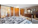 Spacious bedroom featuring a king-sized bed, wood furnishings, and a sliding barn door to the en suite bathroom at 2013 S Holland St, Lakewood, CO 80227