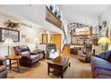 Spacious living room featuring ample seating, natural light, and an open staircase, creating an inviting and airy atmosphere at 2013 S Holland St, Lakewood, CO 80227