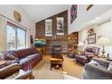 Cozy living room with a brick fireplace, high ceilings, and natural light, perfect for gatherings and relaxation at 2013 S Holland St, Lakewood, CO 80227