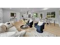 Open-concept living area with modern decor, light wood floors, and stylish seating at 6526 S Elmwood St, Littleton, CO 80120