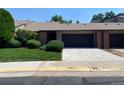 Exterior view of townhouse featuring attached garage, brick accents, and manicured lawn at 540 S Forest St # A2, Denver, CO 80246
