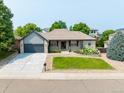 Inviting single-story home with a lush front yard and gray accents at 1735 Crestone Dr, Longmont, CO 80504