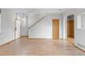 Spacious living room with light hardwood flooring, neutral walls, and stairs to second level at 6202 Ralston St, Frederick, CO 80530