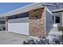 Close-up of the brick and siding on the garage, showing the house number at 8745 W Ottawa Ave, Littleton, CO 80128