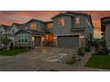 Beautiful two-story home with a long driveway and a well-maintained lawn, complemented by a striking sunset backdrop at 6912 Sunstrand Ct, Castle Pines, CO 80108