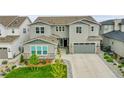 Aerial view of a two-story home with a landscaped yard and a long driveway, featuring a mix of stone and siding at 6912 Sunstrand Ct, Castle Pines, CO 80108