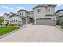 Charming two-story home with a well-manicured lawn, stone accents, and a driveway leading to an attached garage at 6912 Sunstrand Ct, Castle Pines, CO 80108