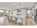 Bright kitchen with a large island, modern appliances, and pendant lighting at 6912 Sunstrand Ct, Castle Pines, CO 80108