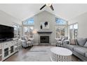 Bright living room with vaulted ceilings, large windows, fireplace and modern furnishings at 6393 Laguna Cir, Highlands Ranch, CO 80130