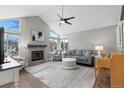 Spacious living room features vaulted ceilings, large windows and a cozy stone fireplace at 6393 Laguna Cir, Highlands Ranch, CO 80130