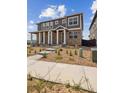 Two-story home with stone accents, covered porch, and landscaped front yard under a blue sky at 18708 E 99Th Ave, Commerce City, CO 80022