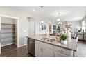 Bright kitchen featuring a large island with stainless steel dishwasher and a view of the stairway at 1923 Westport Ave, Berthoud, CO 80513