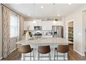Bright kitchen with a large island, stainless steel appliances, pendant lighting and a walk in pantry at 1923 Westport Ave, Berthoud, CO 80513