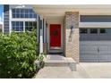 Inviting front porch with a bright red door, brick accents, and well-maintained landscaping at 2261 Alpine Dr, Erie, CO 80516
