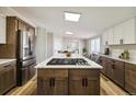 A bright kitchen features a large center island with a stovetop, counter seating, and modern white and brown cabinets at 43343 E Arkansas Pl, Bennett, CO 80102