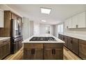 Kitchen island with marble countertop with a built-in cooktop and stainless appliances at 43343 E Arkansas Pl, Bennett, CO 80102