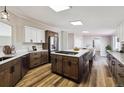 A modern kitchen features wooden floors, white cabinetry, and a large center island with a built-in stovetop at 43343 E Arkansas Pl, Bennett, CO 80102