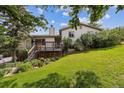 Charming home exterior featuring a spacious deck and lush, landscaped backyard on a sunny day at 6334 Cherokee Dr, Sedalia, CO 80135