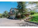 Charming home with multiple decks, two-car garage, and landscaped yard showcasing curb appeal and outdoor living spaces at 6334 Cherokee Dr, Sedalia, CO 80135