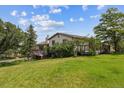 Beautiful home exterior with mature trees and an expansive lawn, creating a serene and inviting atmosphere at 6334 Cherokee Dr, Sedalia, CO 80135