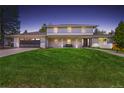 Two-story home with a dark garage and an expansive green lawn, front porch, and walkway at 5853 S Havana Ct, Englewood, CO 80111