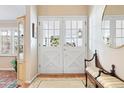 Bright foyer featuring double glass doors, hardwood floors, and a decorative bench at 4505 S Yosemite St # 106, Denver, CO 80237