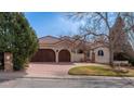 Attractive home featuring a red tile roof, three-car garage, stucco siding, and mature landscaping at 7022 Secrest Ct, Arvada, CO 80007