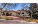 Charming stucco home features a beautiful red tile roof, landscaped yard, and spacious three-car garage at 7022 Secrest Ct, Arvada, CO 80007