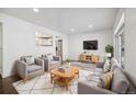 Inviting living room featuring a plush rug, comfortable seating, and an open view to the kitchen at 348 Emery Rd, Northglenn, CO 80233