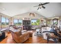 Bright living room with hardwood floors, vaulted ceilings, large windows offering expansive views, and a ceiling fan at 8855 E Parker Rd, Parker, CO 80138